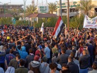 Iraqi followers of influential cleric Moqtada Sadr (with batons) clash with protesters as they raid an anti-government protest camp in the central holy city of Najaf on February 5, 2020. - Seven people were shot dead today in Iraq's shrine city of Najaf after supporters of powerful cleric Moqtada Sadr …