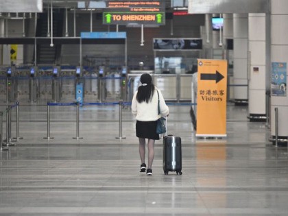 A woman walks to the departure hall of Shenzhen Bay Port Hong Kong Port Area on February 8, 2020. - Hong Kong began enforcing a mandatory two-week quarantine for anyone arriving from mainland China, a dramatic escalation of its bid to stop the deadly new coronavirus from spreading. (Photo by …