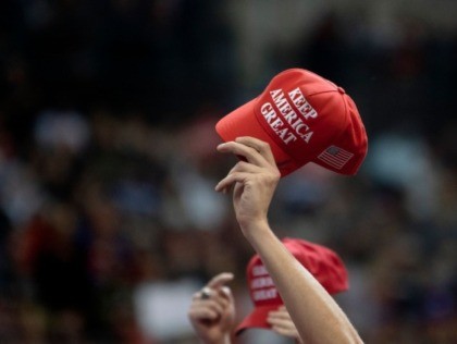 Supporters hold up MAGA hats as US President Donald Trump speaks during a rally in Manches