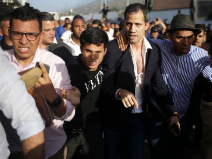 TOPSHOT - Venezuelan opposition leader and self-proclaimed acting president Juan Guaido is escorted to his car after arriving at Simon Bolivar International Airport in Maiquetia, Vargas state, Venezuela on February 11, 2020. - Guaido returned to Venezuela after a 23-day international tour to revitalize pressure on President Nicolas Maduro, his …