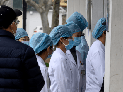 Nurses wearing protective face masks enter a community hospital in Shanghai on February 13, 2020. - China's official death toll and infection numbers from the deadly COVID-19 coronavirus spiked dramatically on February 13 after authorities changed their counting methods, fuelling concern the epidemic is far worse than being reported. (Photo …