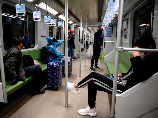 Subway passengers wear protective facemasks in Shanghai on February 13, 2020. - The number of deaths and new cases from China's COVID-19 coronavirus outbreak spiked dramatically on February 13 after authorities changed the way they count infections in a move that will likely fuel speculation that the severity of the outbreak has been under-reported. (Photo by NOEL CELIS / AFP) (Photo by NOEL CELIS/AFP via Getty Images)