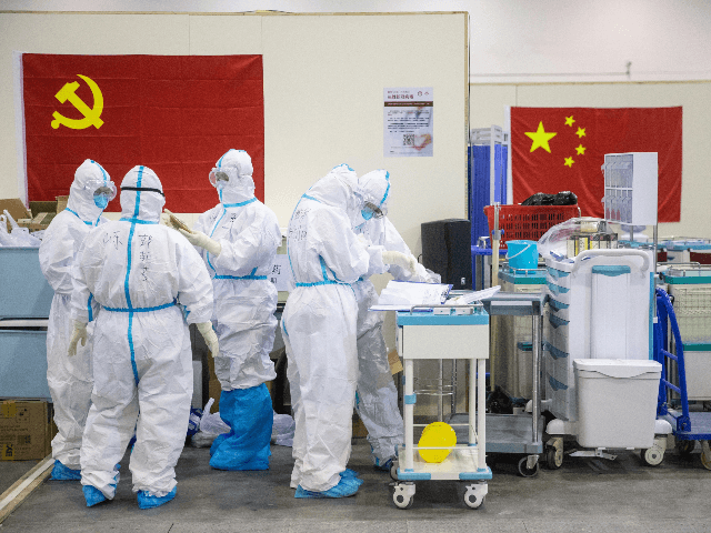 This photo taken on February 17, 2020 shows medical staff members working at an exhibition centre converted into a hospital in Wuhan in China's central Hubei province. - The death toll from the COVID-19 coronavirus epidemic jumped to 1,868 in China on February 18 after 98 more people died, according …