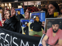 Mourners hold up photos, believed to be of vicitims, during a vigil close to a crime scene in Hanau, near Frankfurt am Main, western Germany, on February 20, 2020, after at least nine people were killed in two shootings late on February 19, 2020. - The suspect in two shootings …