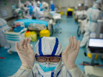 This photo taken on February 22, 2020 shows a nurse adjusting his goggles in an intensive care unit treating COVID-19 coronavirus patients at a hospital in Wuhan, in China's central Hubei province. - China on February 26 reported 52 new coronavirus deaths, the lowest figure in more than three weeks, …