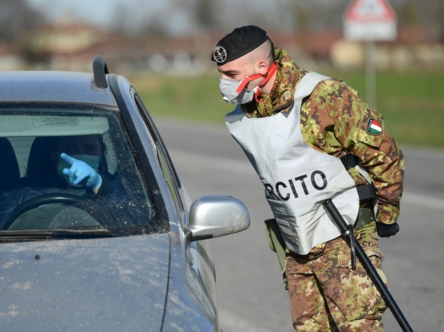 An Italian Army soldier talks with a driver at a cordoned areas' check-point, few kil