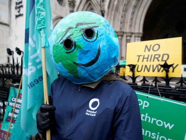 A campaigner wearing a papier-mache globe on his head is seen outside the Royal Courts of Justice in London on February 27, 2020 after a decision by the Court of Appeal on legal challenges to the UK government's approval of plans to expand capacity at Heathrow airport. - Britain's Court …