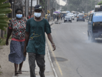 People walk along a main road wearing face masks at Yaba in Lagos, on February 28, 2020. - Residents of Nigeria's economic hub Lagos scrambled for hygiene products after the chaotic megacity of 20 million announced the first confirmed case of new coronavirus in sub-Saharan Africa. Health Minister Osagie Ehanire …