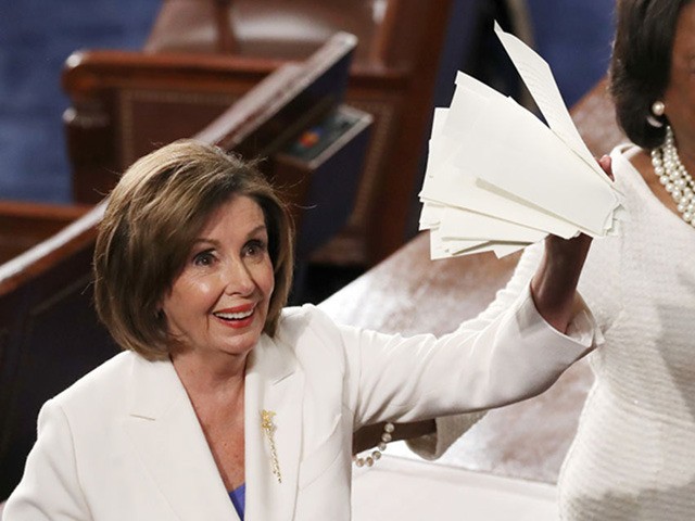 WASHINGTON, DC - FEBRUARY 04: House Speaker Rep. Nancy Pelosi (D-CA) (L) holds up the ripp