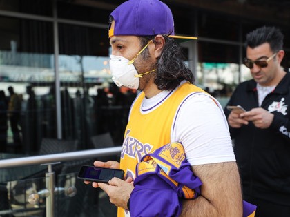 LOS ANGELES, CALIFORNIA - FEBRUARY 24: A fan wears a protective mask as people wait in lin