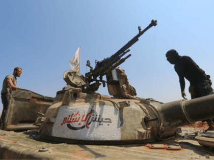 Rebel forces from Jaysh al-Islam (Army of Islam) stand on a tank as they hold a position o