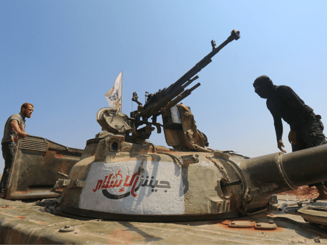 Rebel forces from Jaysh al-Islam (Army of Islam) stand on a tank as they hold a position o