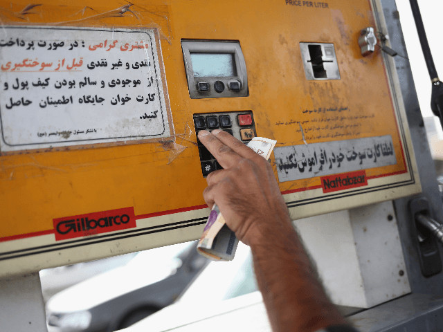 A man prepares to pay at the gas pump at a service station on June 3, 2014 in Shahinshahr,