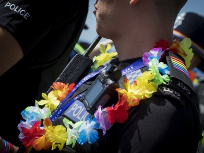 BRIGHTON, ENGLAND - AUGUST 05: A police officer wears a rainbow garland during the annual Brighton Pride Parade on August 5, 2017 in Brighton, England. (Photo by Tristan Fewings/Getty Images)
