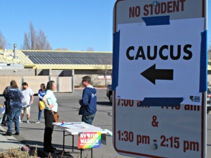Volunteers for various campaigns talk to voters as they enter a presidential caucus site at Mendive Middle School in Sparks, Nev., on Saturday, Feb. 22, 2020. (AP Photo/Scott Sonner)
