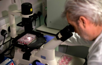 Doctor Paul McKay, who is working on an vaccine for the 2019-nCoV strain of the novel coronavirus, Covid-19,, poses for a photograph using a microscope to look at bacteria containing coronavirus, Covid-19, DNA fragments, in a research lab at Imperial College School of Medicine (ICSM) in London on February 10, …