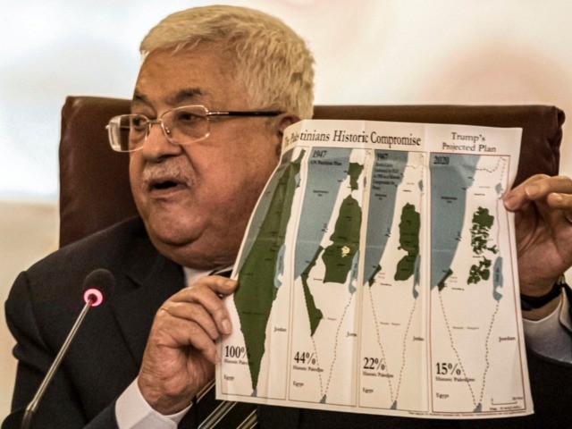 Palestinian president Mahmud Abbas holds a placard showing maps of (L to R) historical Pal