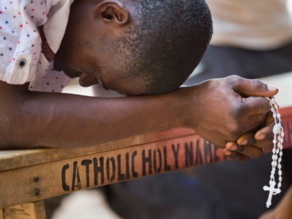 A Nigerian man prays in the yard of the St Charles Catholic Church, scene of a 2014 bomb attack blamed on Boko Haram Islamic insurgents, in the mainly Christian Sabon Gari neighborhood of Kano, northern Nigeria on Palm Sunday, March 29, 2015. Normally the church would be packed with up …