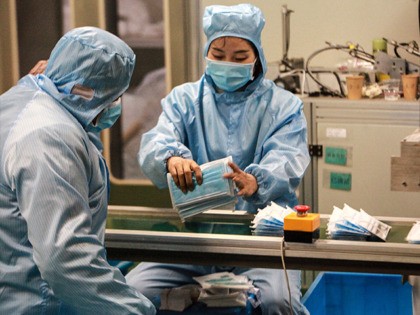 TOPSHOT - This photo taken on January 26, 2020 shows workers producing facemasks at a factory in Yangzhou in China's eastern Jiangsu province, to support the supply of medical materials during a deadly virus outbreak which began in Wuhan. - At least 81 people have died since the new strain …