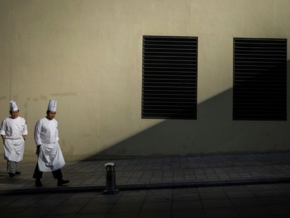 Chefs walk along a sidewalk in Beijing on January 14, 2020. - China's trade surplus with the United States narrowed last year as the world's two biggest economies exchanged punitive tariffs in a bruising trade war, official data showed Tuesday. (Photo by NOEL CELIS / AFP) (Photo by NOEL CELIS/AFP …