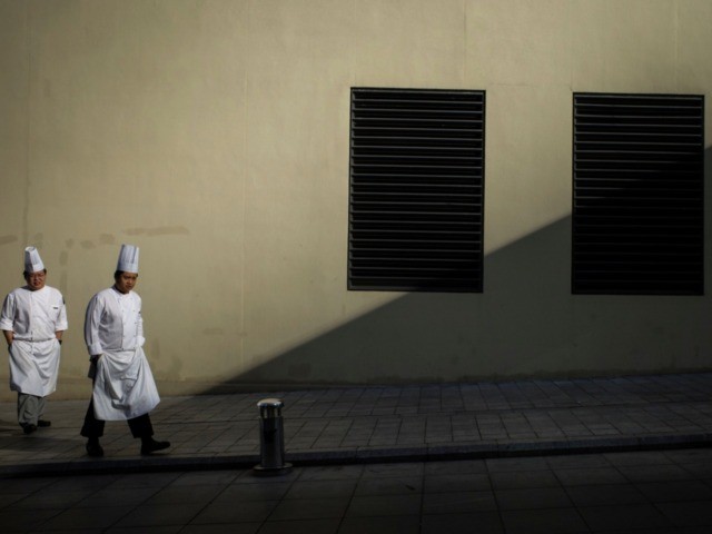 Chefs walk along a sidewalk in Beijing on January 14, 2020. - China's trade surplus with the United States narrowed last year as the world's two biggest economies exchanged punitive tariffs in a bruising trade war, official data showed Tuesday. (Photo by NOEL CELIS / AFP) (Photo by NOEL CELIS/AFP …