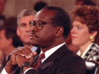 U.S. Supreme Court Justice nominee Judge Clarence Thomas is shown during his testimony before the Senate Judiciary Committee on Capitol Hill in Washington, D.C., Oct. 11, 1991. Thomas denies the charges of sexual harassment brought against him. His wife, Virginia, sits behind him. (AP Photo/Greg Gibson)