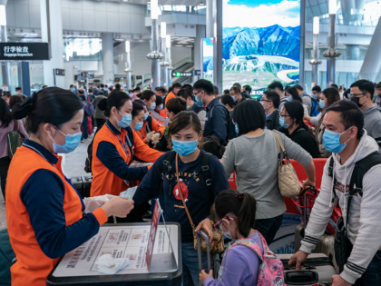 HONG KONG, CHINA - JANUARY 23: Travellers wearing face mask wait in line at the departure hall of West Kowloon Station on January 23, 2020 in Hong Kong, China. Hong Kong reported its first two cases of Wuhan coronavirus infections as the number of those who have died from the …