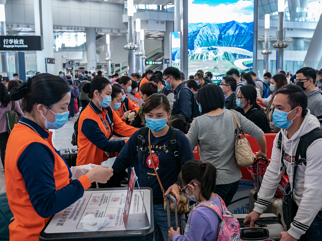 HONG KONG, CHINA - JANUARY 23: Travellers wearing face mask wait in line at the departure