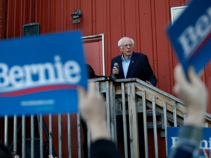 Democratic presidential candidate Sen. Bernie Sanders, I-Vt., accompanied by his wife Jane O'Meara Sanders, right, speaks to an overflow crowd at a Super Bowl watch party campaign event, Sunday, Feb. 2, 2020, in Des Moines, Iowa. (AP Photo/John Locher)