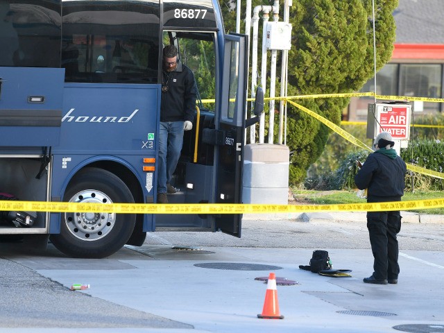 Investigators are seen outside of a Greyhound bus after a passenger was killed on board on