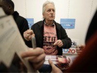 Actor Michael Douglas, center, greets people before speaking in support of Democratic presidential candidate and former New York City Mayor Mike Bloomberg, not shown, at a Bloomberg campaign office, in Quincy, Mass., Sunday, Feb. 23, 2020. (AP Photo/Steven Senne)