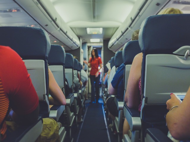 Flight attendant in an airplane cabin.