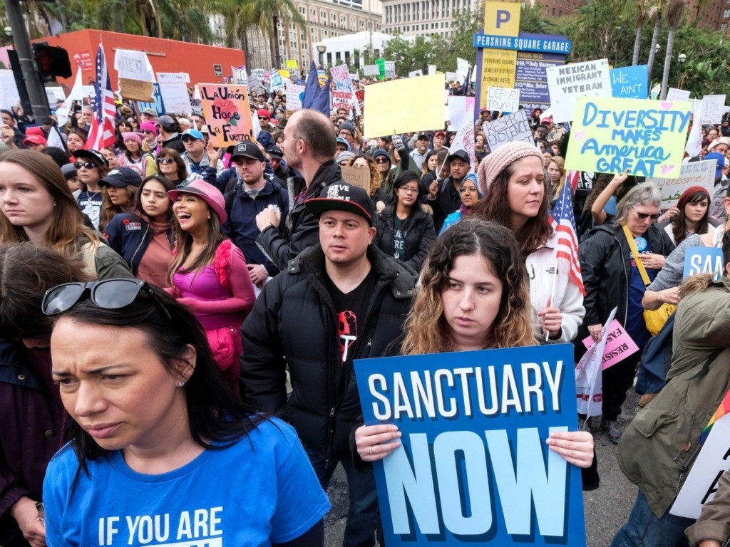 FILE - In this Feb. 18, 2017, file photo, thousands of people take part in the "Free the People Immigration March," to protest actions taken by President Donald Trump and his administration, in Los Angeles. A federal appeals court has given the Trump administration a rare legal win in its efforts to crack down on sanctuary cities. In a 2-1 decision Friday, July 12, 2019, the 9th U.S. Circuit Court of Appeals said the Justice Department was within its rights to give priority status for multimillion-dollar community policing grants to departments that agree to cooperate with immigration officials. (AP Photo/Ringo H.W. Chiu, File)