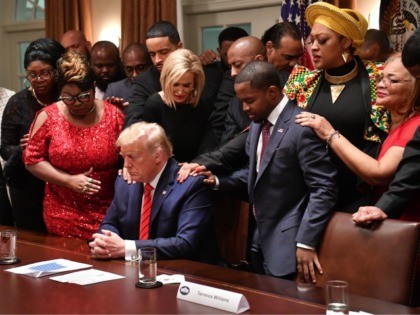 US President Donald Trump (C) stands in a prayer circle during a meeting with African-American leaders in the Cabinet Room of the White House in Washington, DC, on February 27, 2020. (Photo by Nicholas Kamm / AFP) (Photo by NICHOLAS KAMM/AFP via Getty Images)