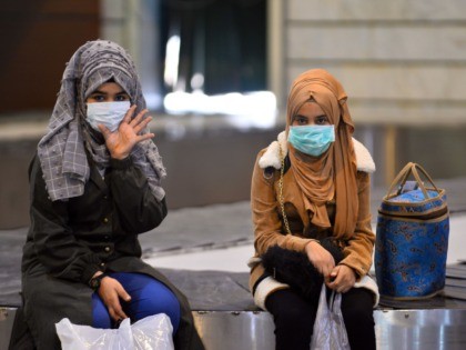 Iraqis returning from Iran wear protective masks upon their arrival at the Najaf International Airport on February 21, 2020, after Iran announced cases of coronavirus infections in the Islamic republic. (Photo by Haidar HAMDANI / AFP) (Photo by HAIDAR HAMDANI/AFP via Getty Images)
