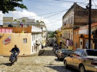 A man rides his motorcycle through an empty street in Santo Domingo, the capital and largest city in Dominican Republic.