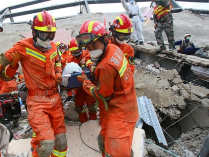 A man (C) is rescued from the rubble of a collapsed hotel in Quanzhou, in China's eastern Fujian province on March 8, 2020. - At least four people were killed following the collapse of a hotel used as a coronavirus quarantine facility in eastern China, the Ministry of Emergency Management …