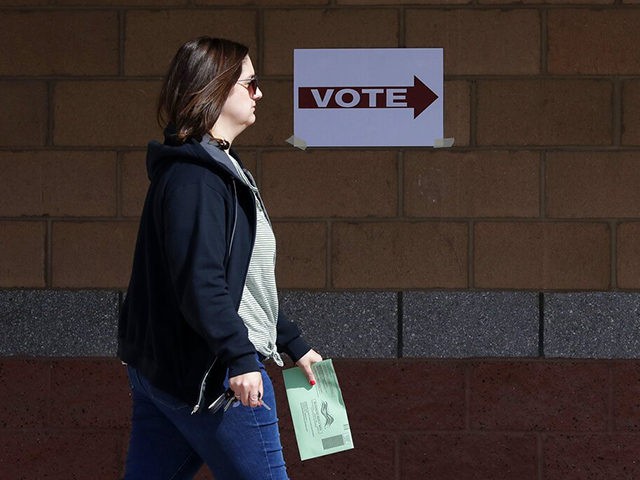 An Arizona voter delivers her mail-in ballot at a polling station for the Arizona presidential preference election Tuesday, March 17, 2020, in Phoenix. (AP Photo/Matt York)
