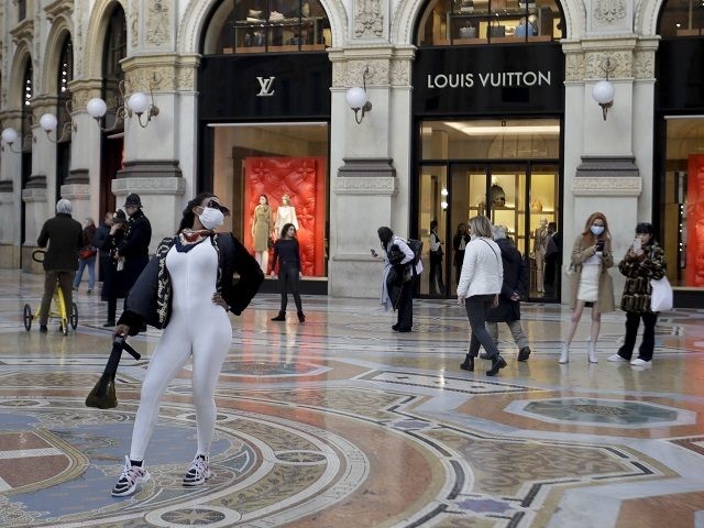 Tourists wearing face masks pose and take photos at the Vittorio Emanuele Gallery shopping