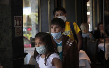 A trio of cousins wear medical masks as a precaution against the spread of the new coronav