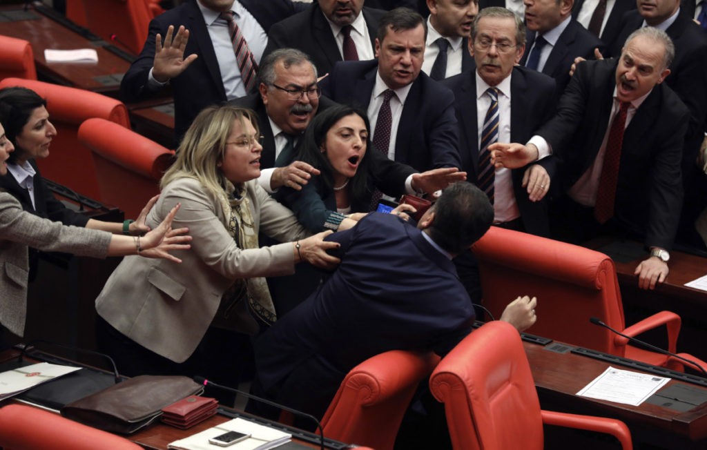Legislators push each other as a brawl breaks out in Turkey's parliament in Ankara, Turkey, Wednesday, March 4, 2020. A fight broke out in the Turkish parliament between lawmakers from opposing parties during a tense discussion about Turkey's military involvement in northwest Syria. (AP Photo)