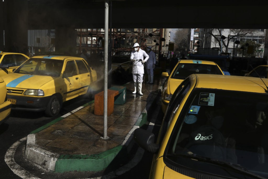 A city worker disinfects a taxi because of the new coronavirus, in Tehran, Iran, Thursday, March 5, 2020.  (AP Photo/Vahid Salemi)