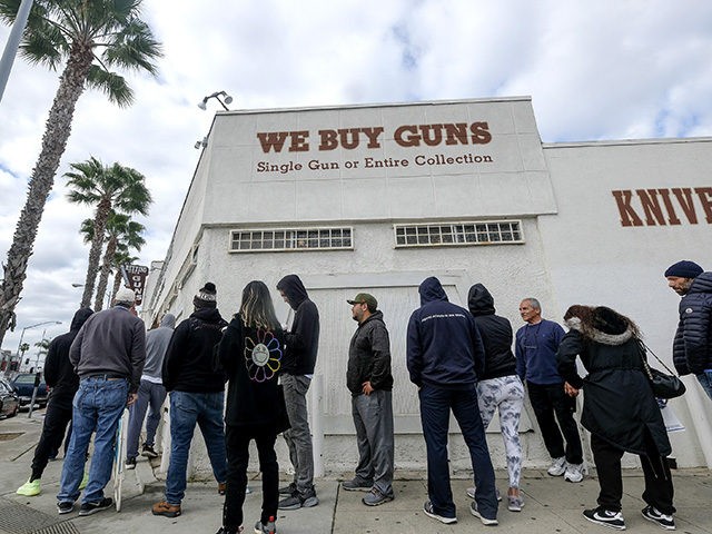 People wait in a line to enter a gun store in Culver City, Calif., Sunday, March 15, 2020. Coronavirus concerns have led to consumer panic buying of grocery staples and now gun stores are seeing a run on weapons and ammunition as panic intensifies. (AP Photo/Ringo H.W. Chiu)
