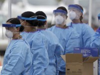 Another shift of medical staff prepare to start woking at a drive-through testing center for COVID-19 in Paramus, N.J., Friday, March 20, 2020. The coronavirus testing center opened Friday in Bergen County which has been the state's hardest-hit area. Gov. Phil Murphy said only those with symptoms should get in …
