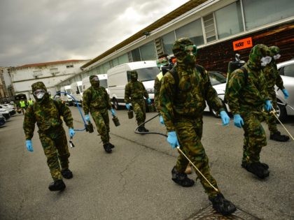 Member of Military Emergency Unit walk with special equipment to disinfect areas to preven