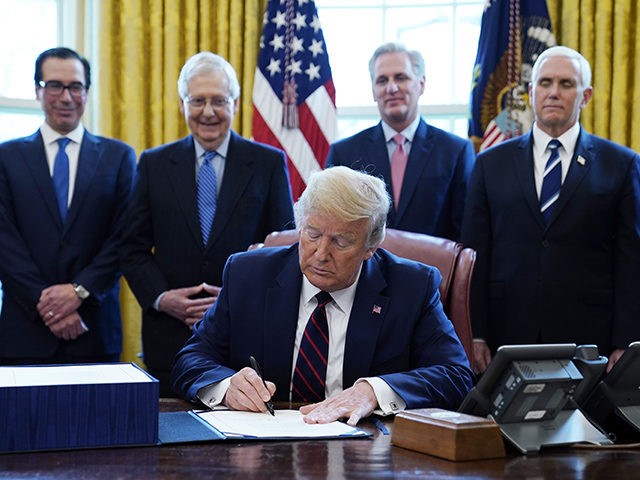 President Donald Trump signs the coronavirus stimulus relief package, at the White House, Friday, March 27, 2020, in Washington, as from left, Treasury Secretary Steven Mnuchin, Senate Majority Leader Mitch McConnell of Ky., House Minority Kevin McCarthy of Calif., and Vice President Mike Pence, look on. (AP Photo/Evan Vucci)