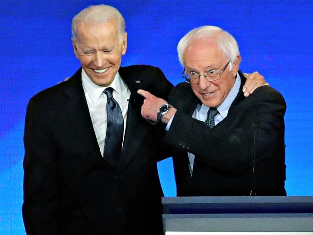 Former US vice president Joe Biden, left, embraces Sen. Bernie Sanders during a Democratic presidential primary debate, February 7, 2020, hosted by ABC News, Apple News, and WMUR-TV at Saint Anselm College in Manchester, New Hampshire. (AP Photo/Elise Amendola)