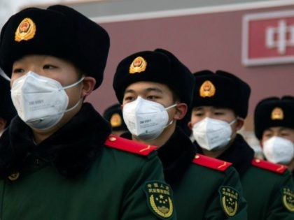 BEIJING, CHINA - JANUARY 26: Chinese police officers wearing masks stand in front of the Tiananmen Gate on January 26, 2020 in Beijing, China. The number of cases of coronavirus rose to 1,975 in mainland China on Sunday. Authorities tightened restrictions on travel and tourism this weekend after putting Wuhan, …