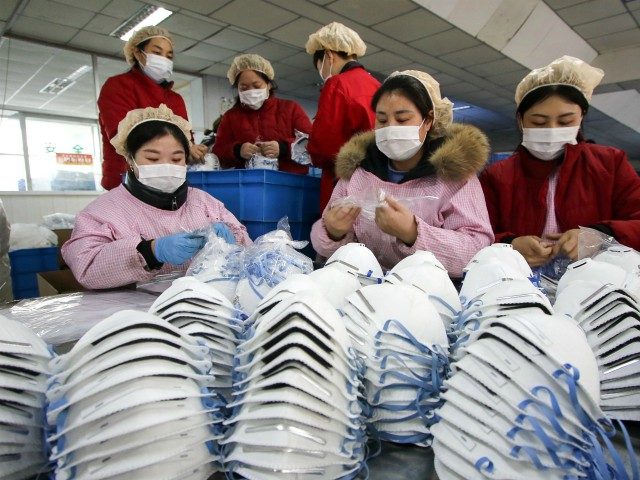 TOPSHOT - This photo taken on January 22, 2020 shows workers producing facemasks at a factory in Handan in China's northern Hebei province. - China banned trains and planes from leaving Wuhan at the centre of a virus outbreak on January 23, seeking to seal off its 11 million people …