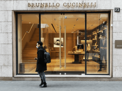 MILAN, ITALY - FEBRUARY 29: A man wears a protective mask as he walks in front of the Bruno Cucinelli store in Via Montenapoleone, the most important road of the fashion district in the city center where all the luxury brand are located on February 29, 2020 in Milan, Italy. …